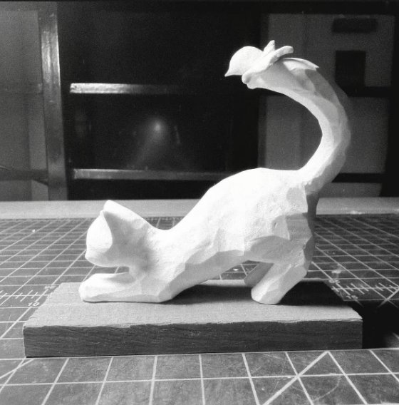 Clay cat stretching, a butterfly on its tail