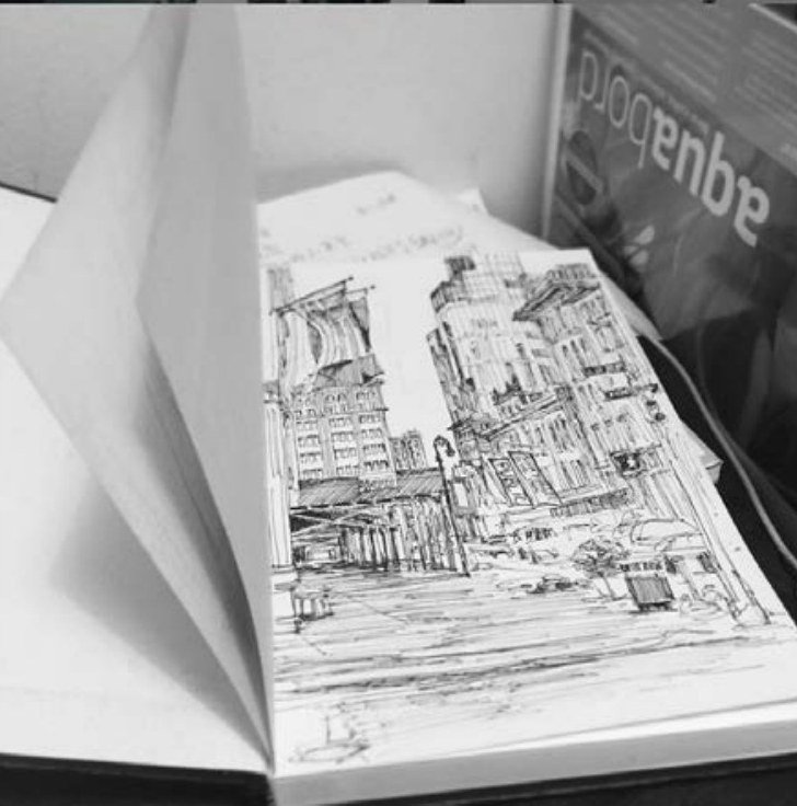 Open sketchbook with a detailed ink drawing of a New York street