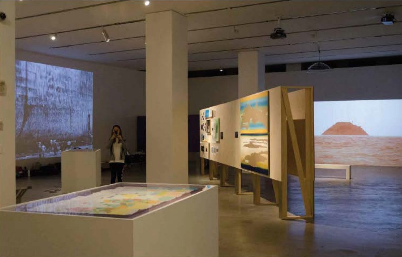 Gallery with projections, a lit table display and wall panels