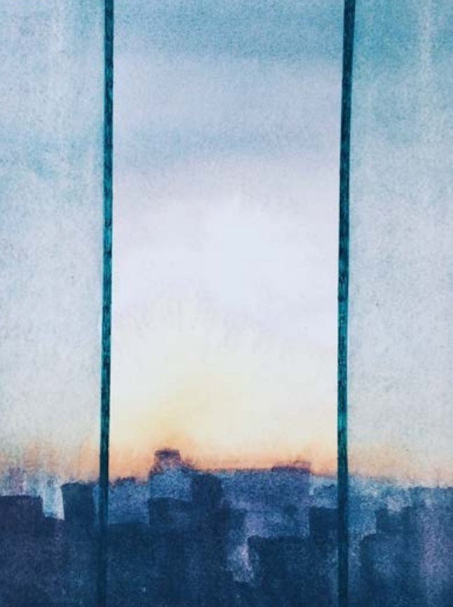 Sunrise over a city skyline seen between two window mullions